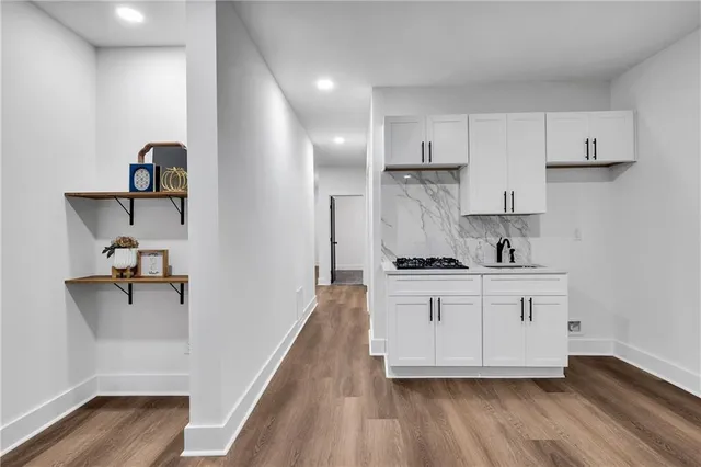 a kitchen with stainless steel appliances white cabinets and wooden floors