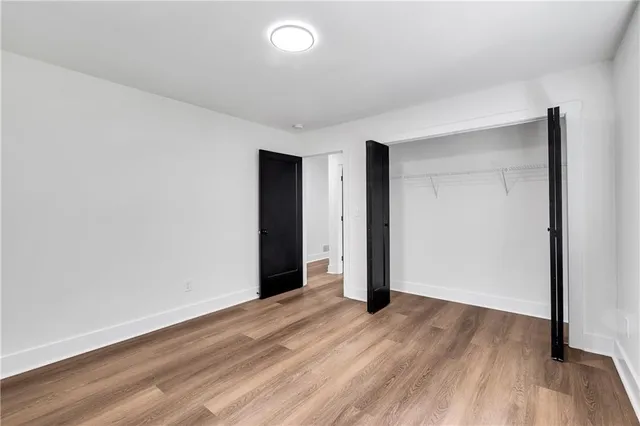 an empty room with wooden floor and closet