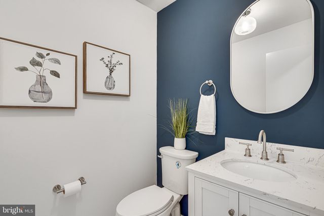 a bathroom with a toilet a sink a mirror a bathtub and vanity