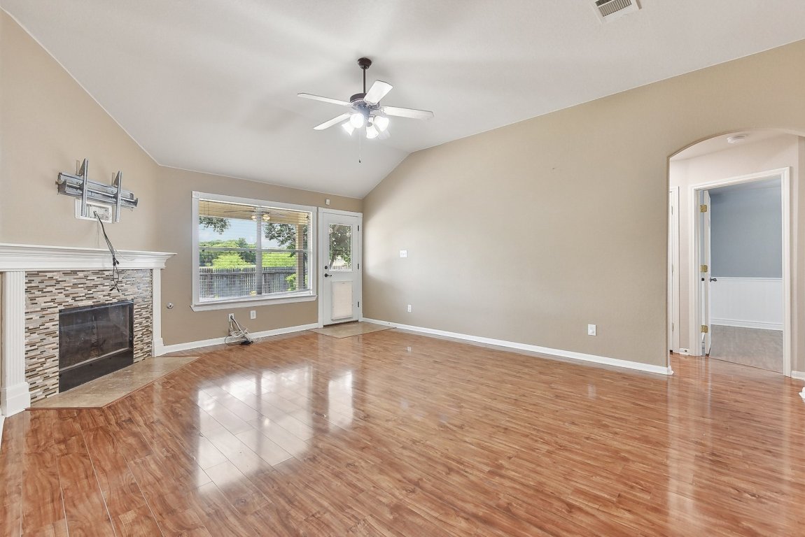 217 Newport Landing Place Round Rock, TX 78665 - Photo 15 of 30 The living offers is highlighted with tall ceilings, fan/fixture, a fire place.