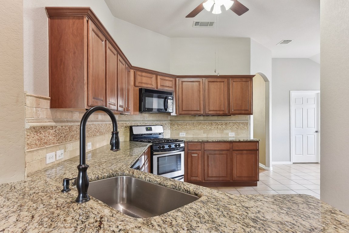 217 Newport Landing Place Round Rock, TX 78665 - Photo 6 of 30 Elegant granite countertops and stainless steel appliances