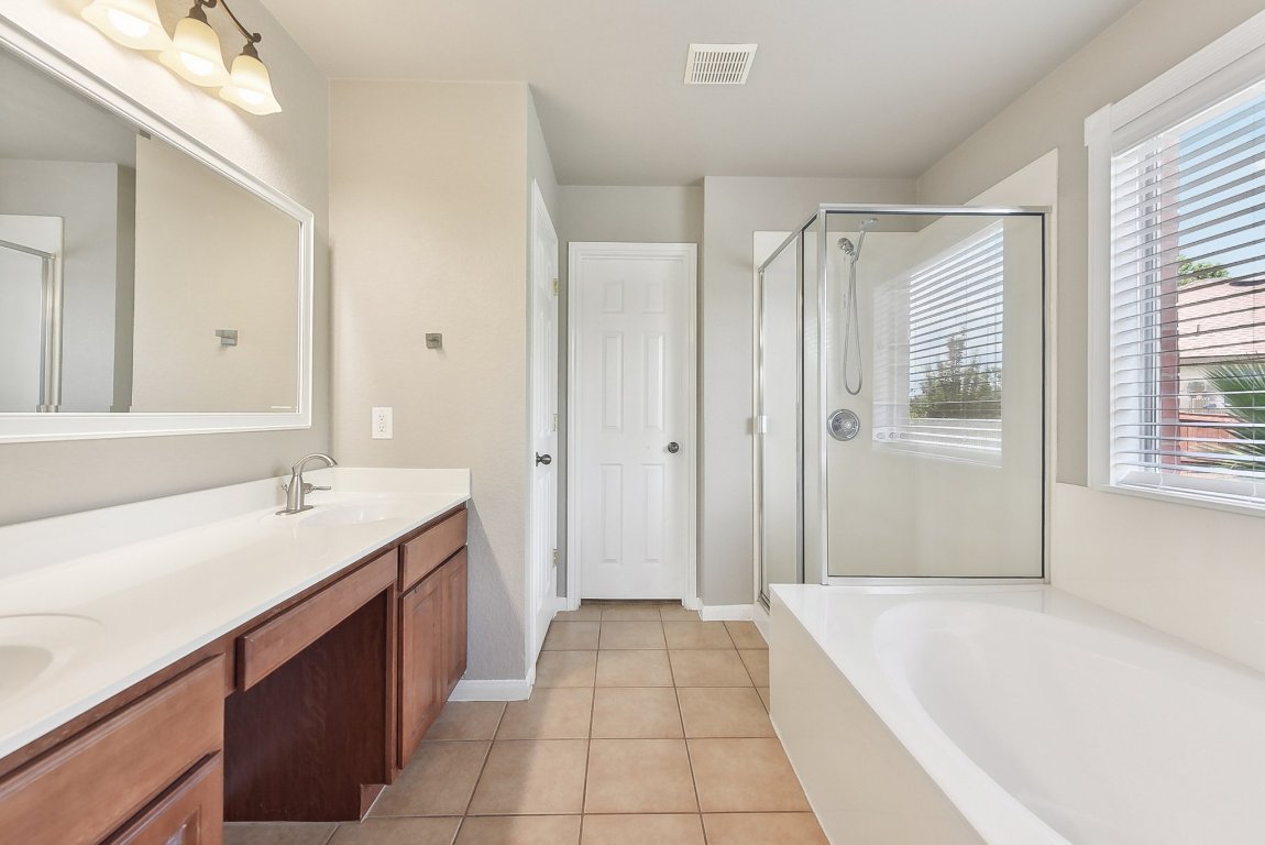 217 Newport Landing Place Round Rock, TX 78665 - Photo 8 of 30 Primary Bathroom offering dual vanities, a separate shower, and garden tub.