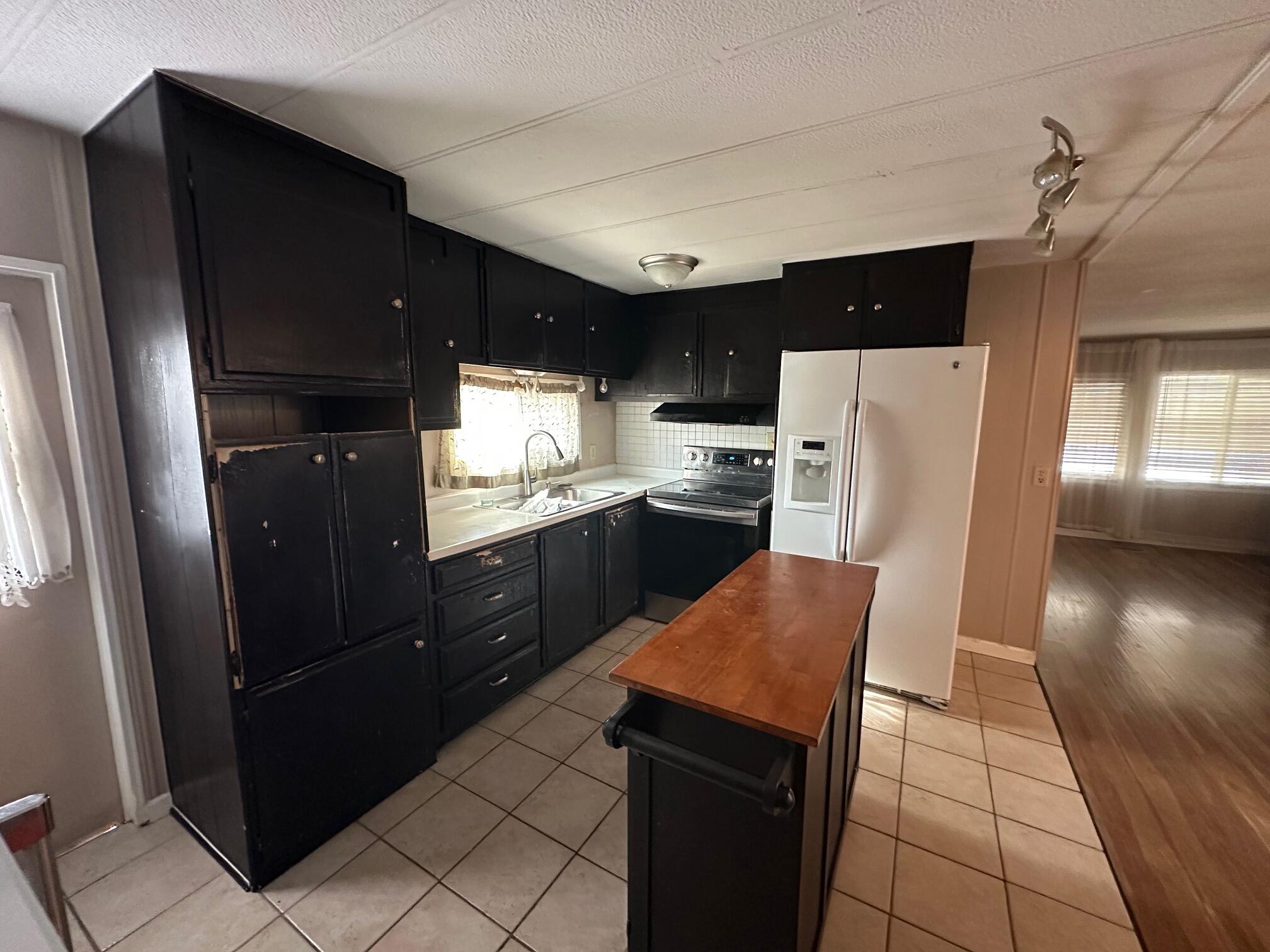 421 Stevens Road, Unit 52 Eagle Point, OR 97524 - Photo 7 of 18 a kitchen with stainless steel appliances kitchen island granite countertop refrigerator stove microwave and cabinets