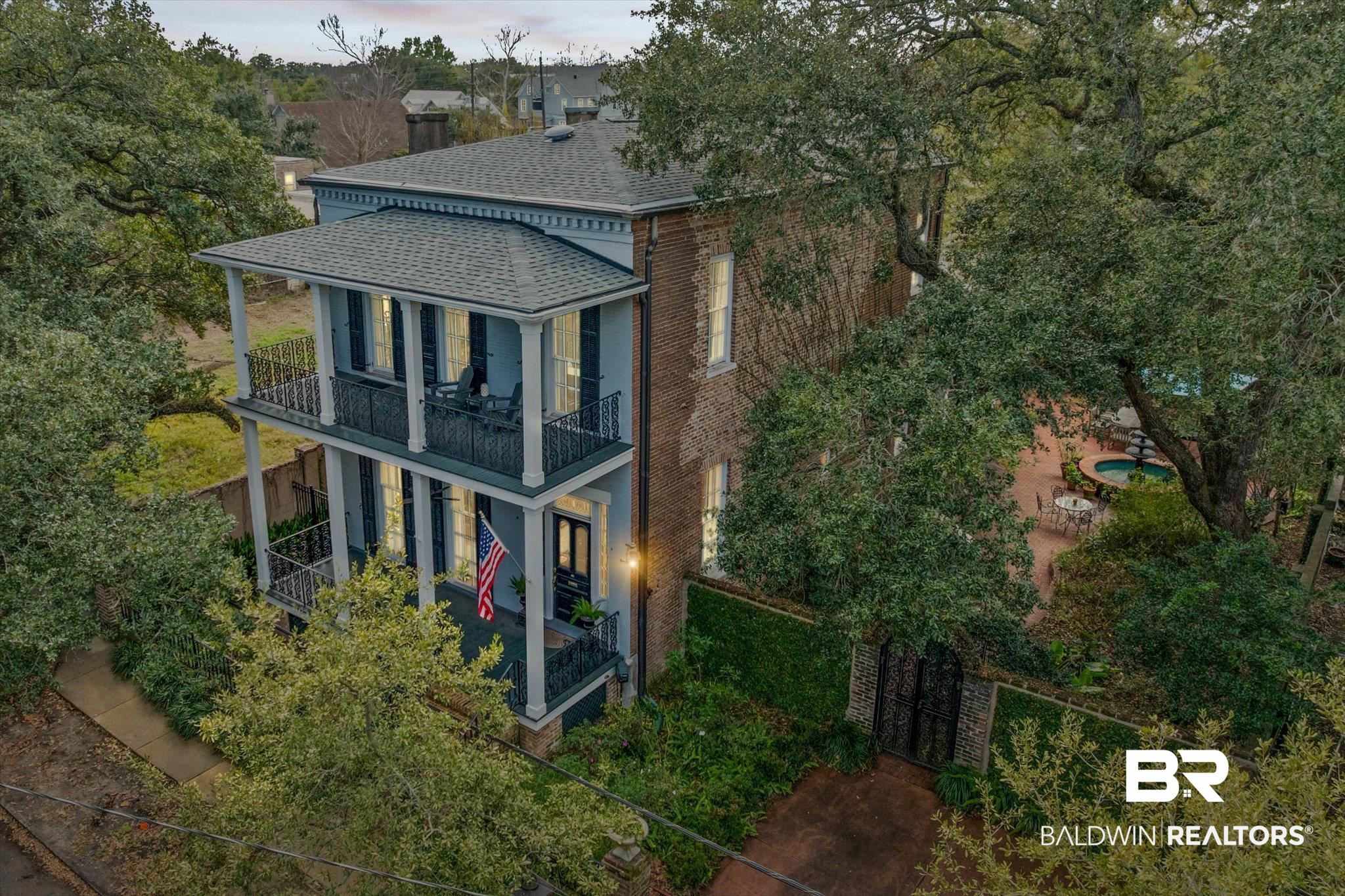 259 North Jackson Street Mobile, AL 36603 - Photo 39 of 42 View of front of property with a shingled roof, a gate, a fenced front yard, brick siding, and a balcony