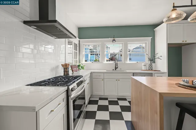 a kitchen with a stove a table and chairs in it