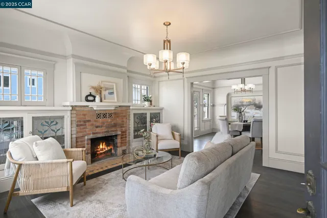 a living room with furniture a chandelier and a fireplace