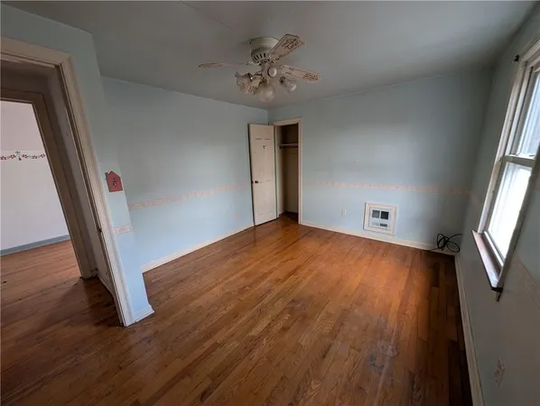 wooden floor in an empty room with a window