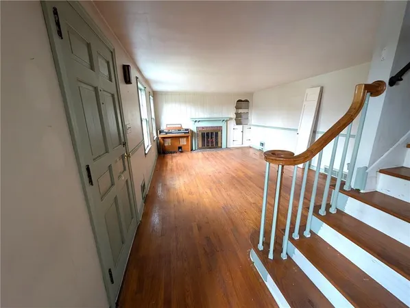 a view of a hallway with wooden floor and stairs