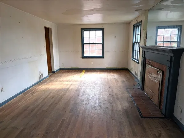 an empty room with wooden floor and a window