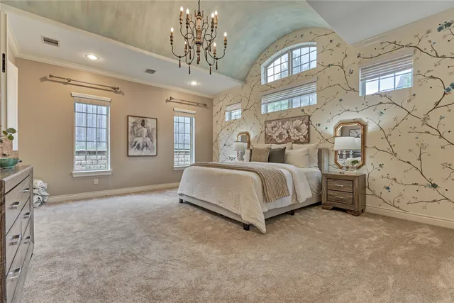 a spacious bedroom with a bed a dresser and next to a window