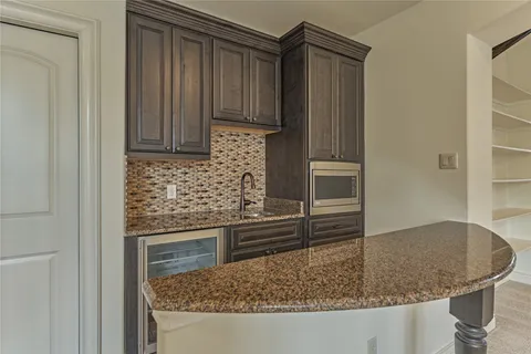 a kitchen with granite countertop a sink and a refrigerator