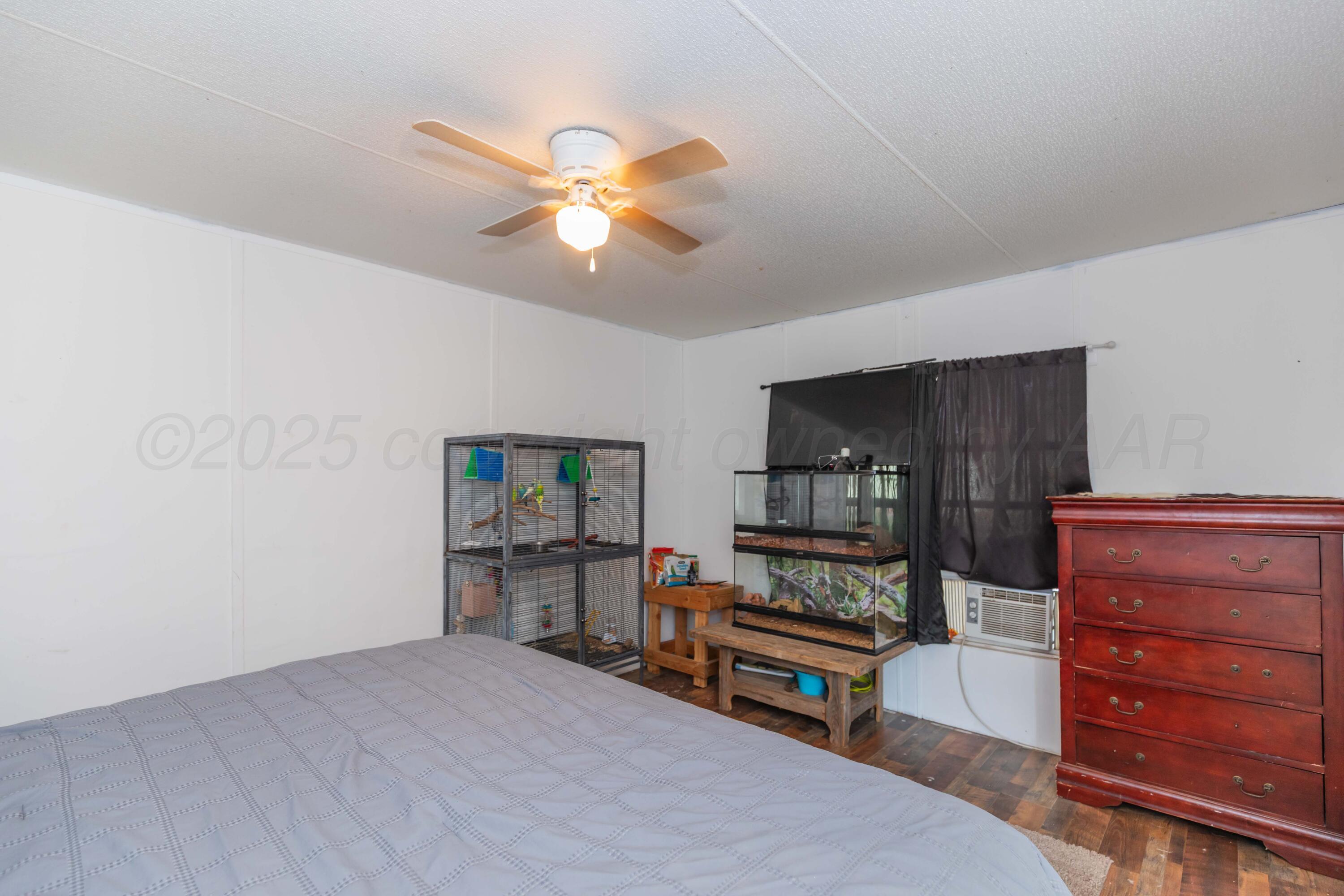 11566 County Road East Pampa, TX 79065 - Photo 16 of 56 a bedroom with furniture and wooden floor