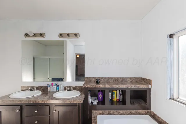 a bathroom with a granite countertop sink and a toilet