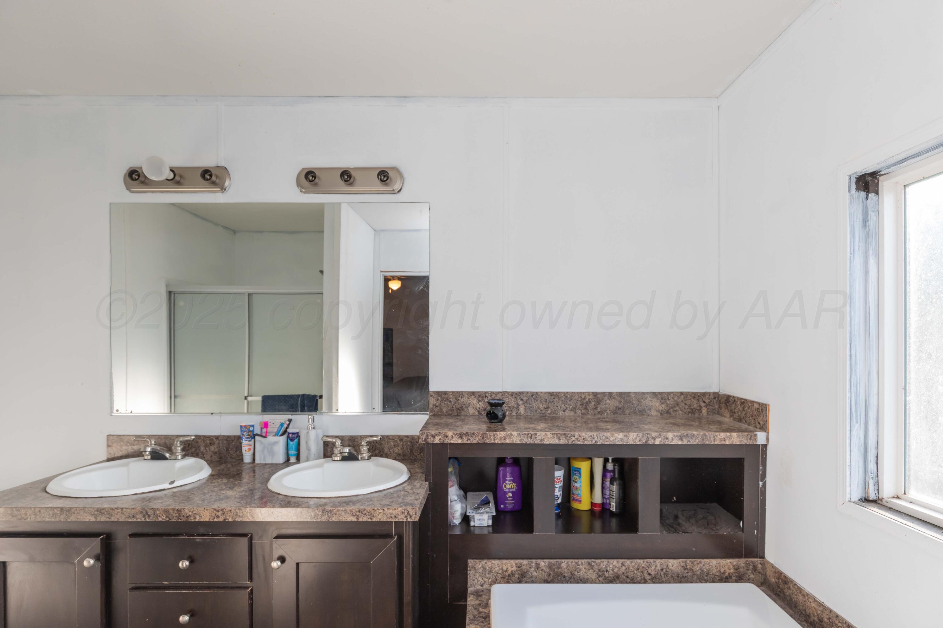 11566 County Road East Pampa, TX 79065 - Photo 17 of 56 a bathroom with a granite countertop sink and a mirror