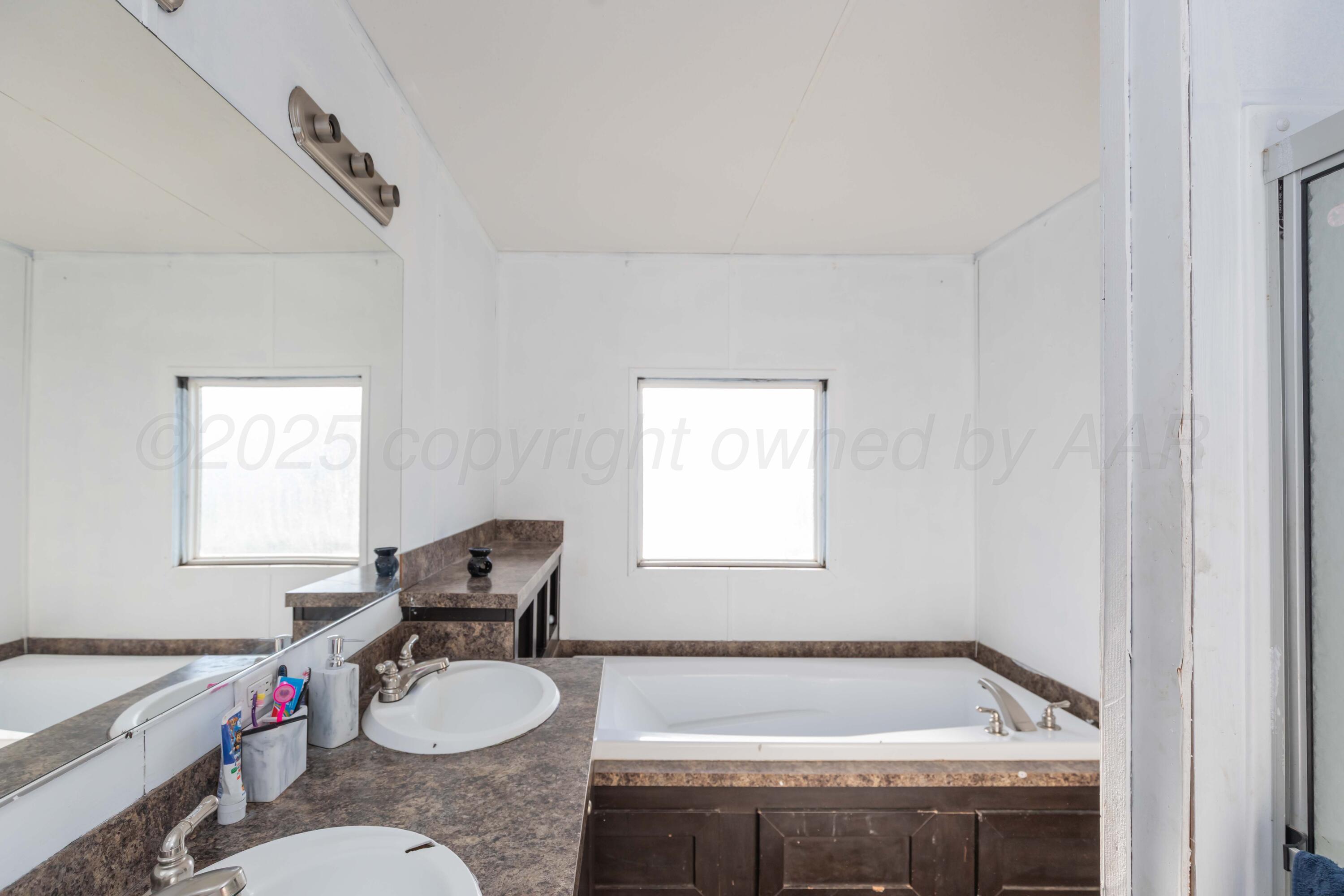 11566 County Road East Pampa, TX 79065 - Photo 19 of 56 a bathroom with a granite countertop sink and a bathtub