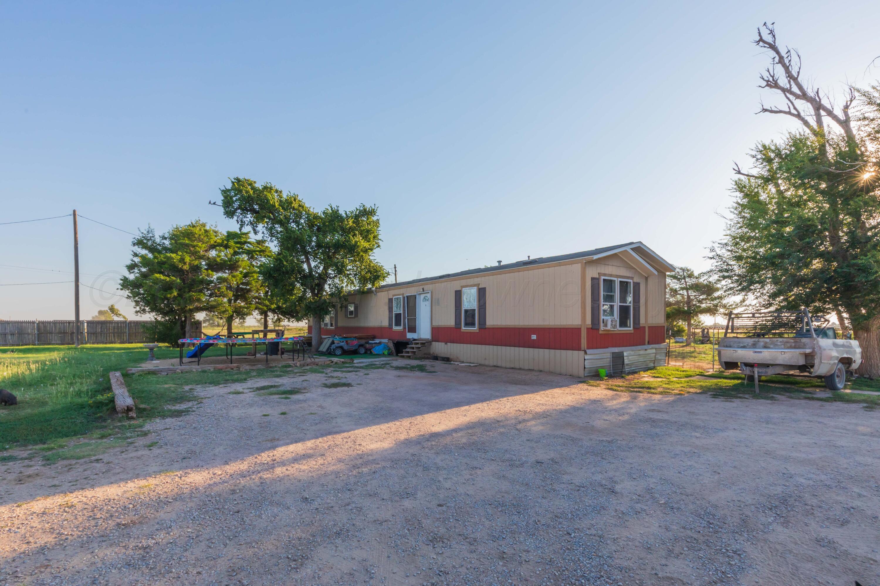 11566 County Road East Pampa, TX 79065 - Photo 2 of 56 a view of a house with a big yard and large trees