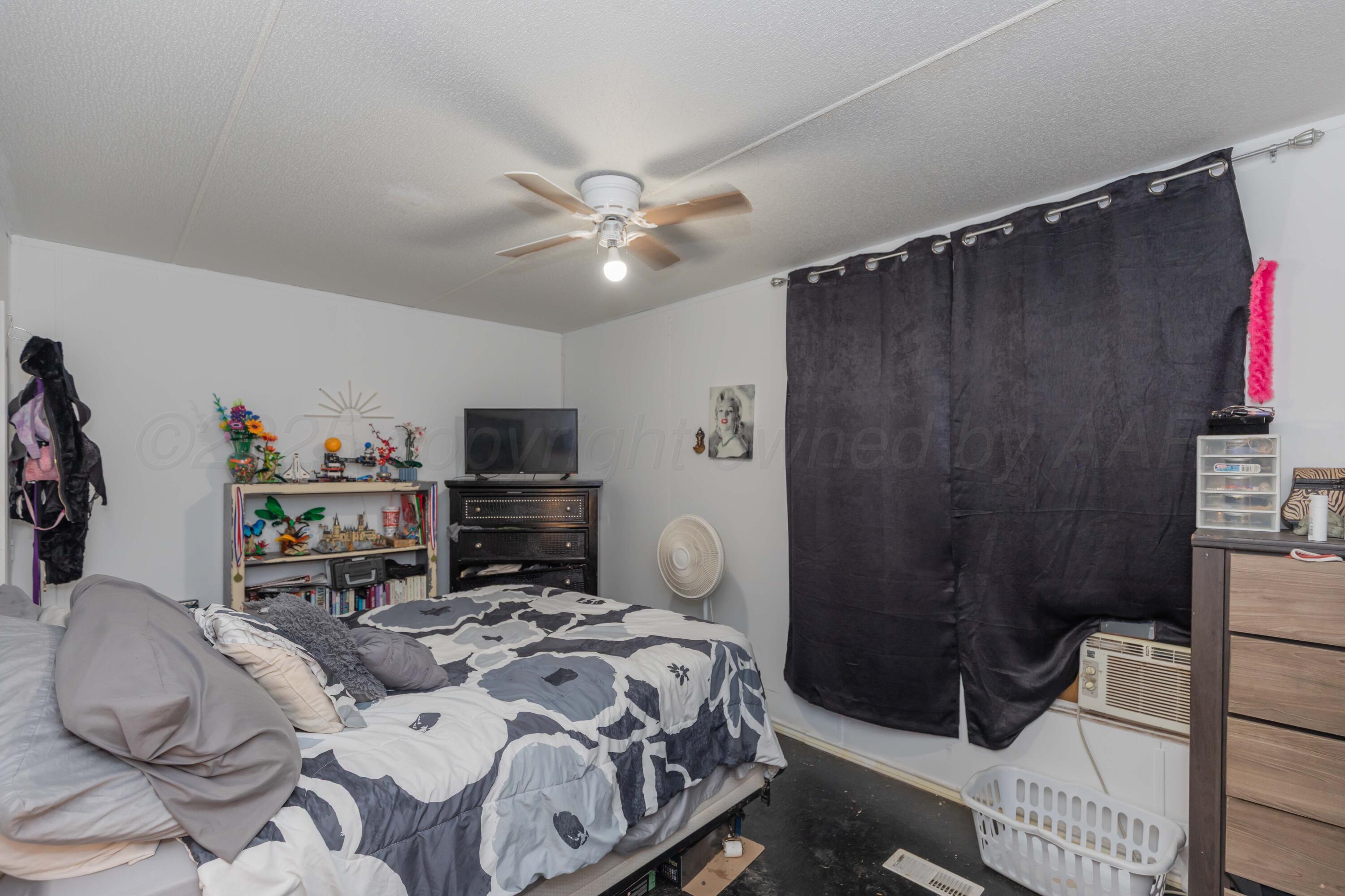 11566 County Road East Pampa, TX 79065 - Photo 21 of 56 a bedroom with a bed and a chandelier