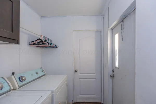 a view of backyard with potted plants and wooden fence