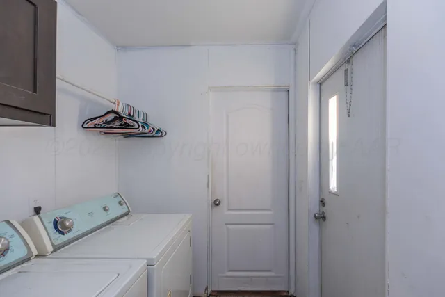 a view of backyard with potted plants and wooden fence