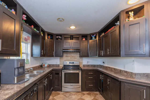 a kitchen with stainless steel appliances granite countertop a stove a sink dishwasher and cabinets with wooden floor