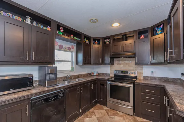 a kitchen with stainless steel appliances a sink stove and cabinets