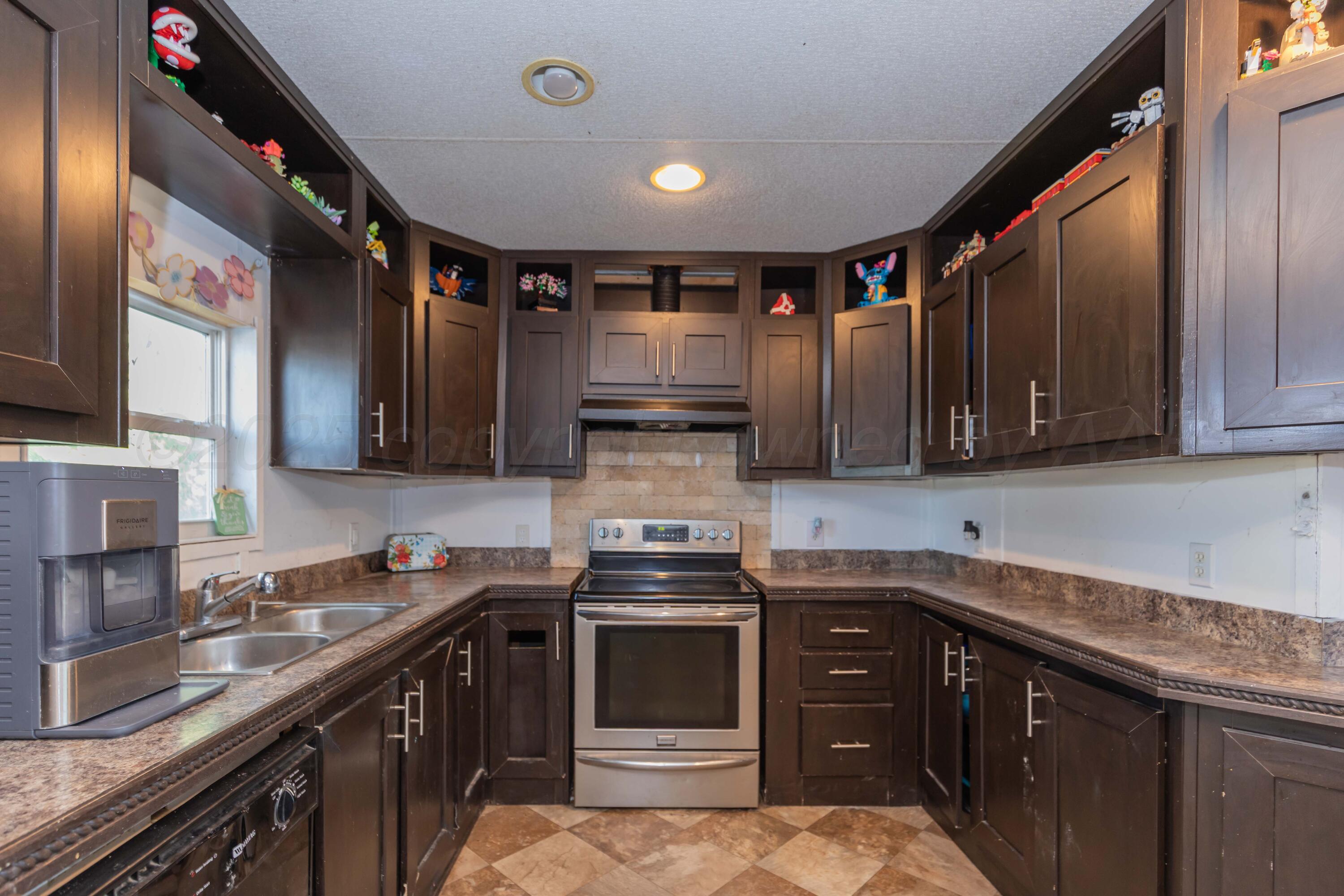 11566 County Road East Pampa, TX 79065 - Photo 10 of 56 a kitchen with stainless steel appliances granite countertop a stove sink and cabinets