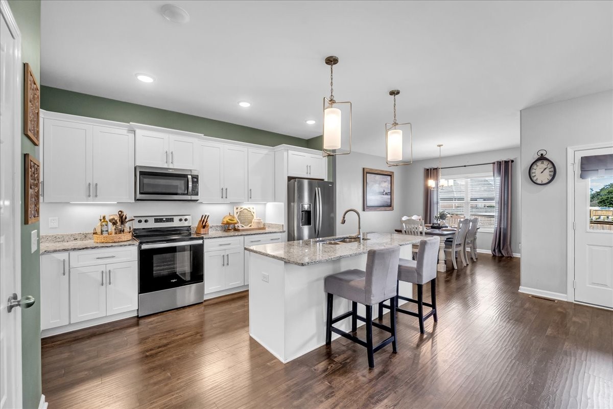 124 Cordell Love Road Smithville, TN 37166 - Photo 14 of 58 a kitchen with stainless steel appliances granite countertop a stove top oven a sink dishwasher a refrigerator and a dining table with wooden floor