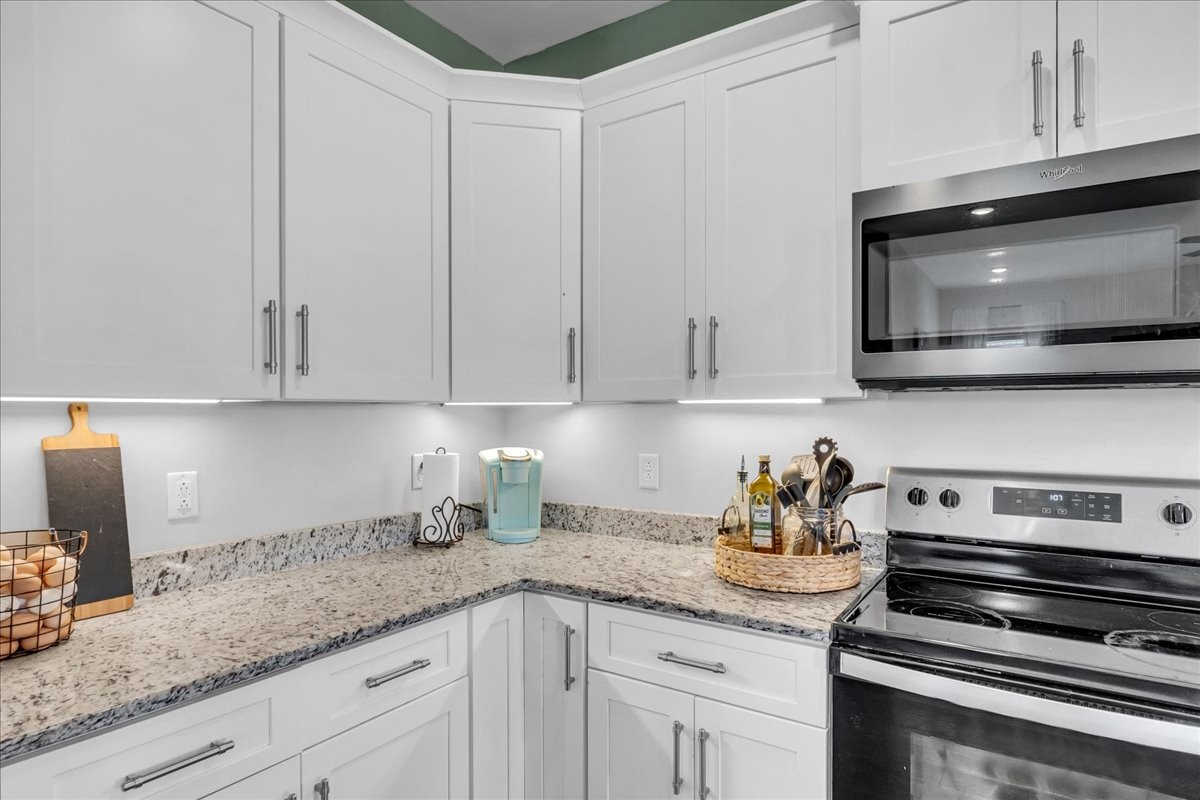 124 Cordell Love Road Smithville, TN 37166 - Photo 18 of 58 a kitchen with granite countertop white cabinets and a stove top oven