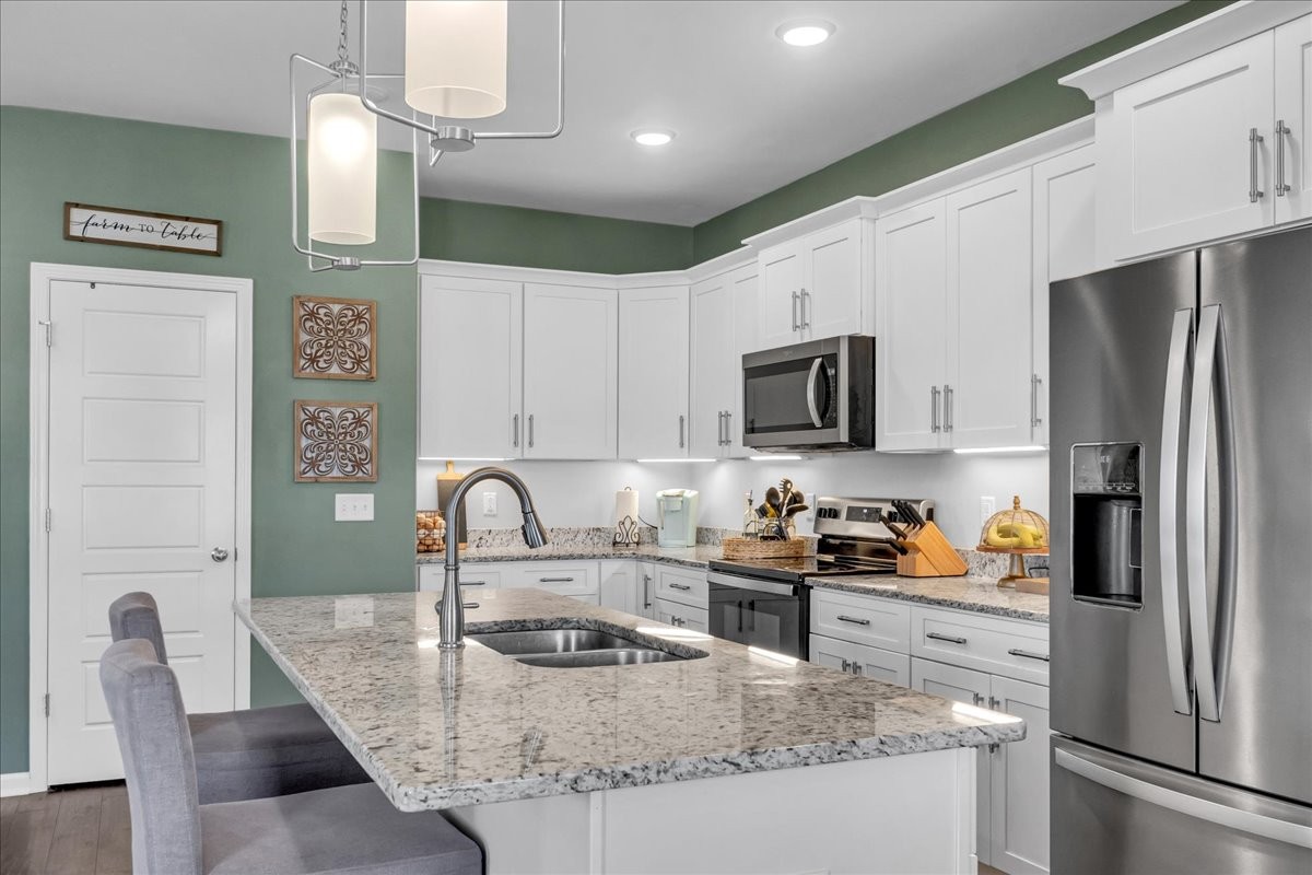 124 Cordell Love Road Smithville, TN 37166 - Photo 22 of 58 a kitchen with granite countertop a refrigerator and a stove top oven