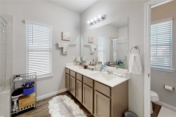 a bathroom with a sink vanity granite and a toilet