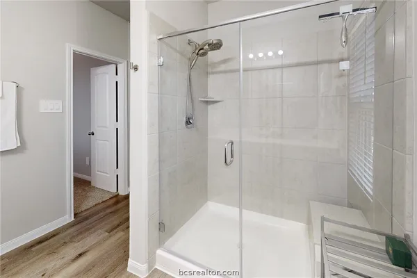 a bathroom with a shower and a glass door