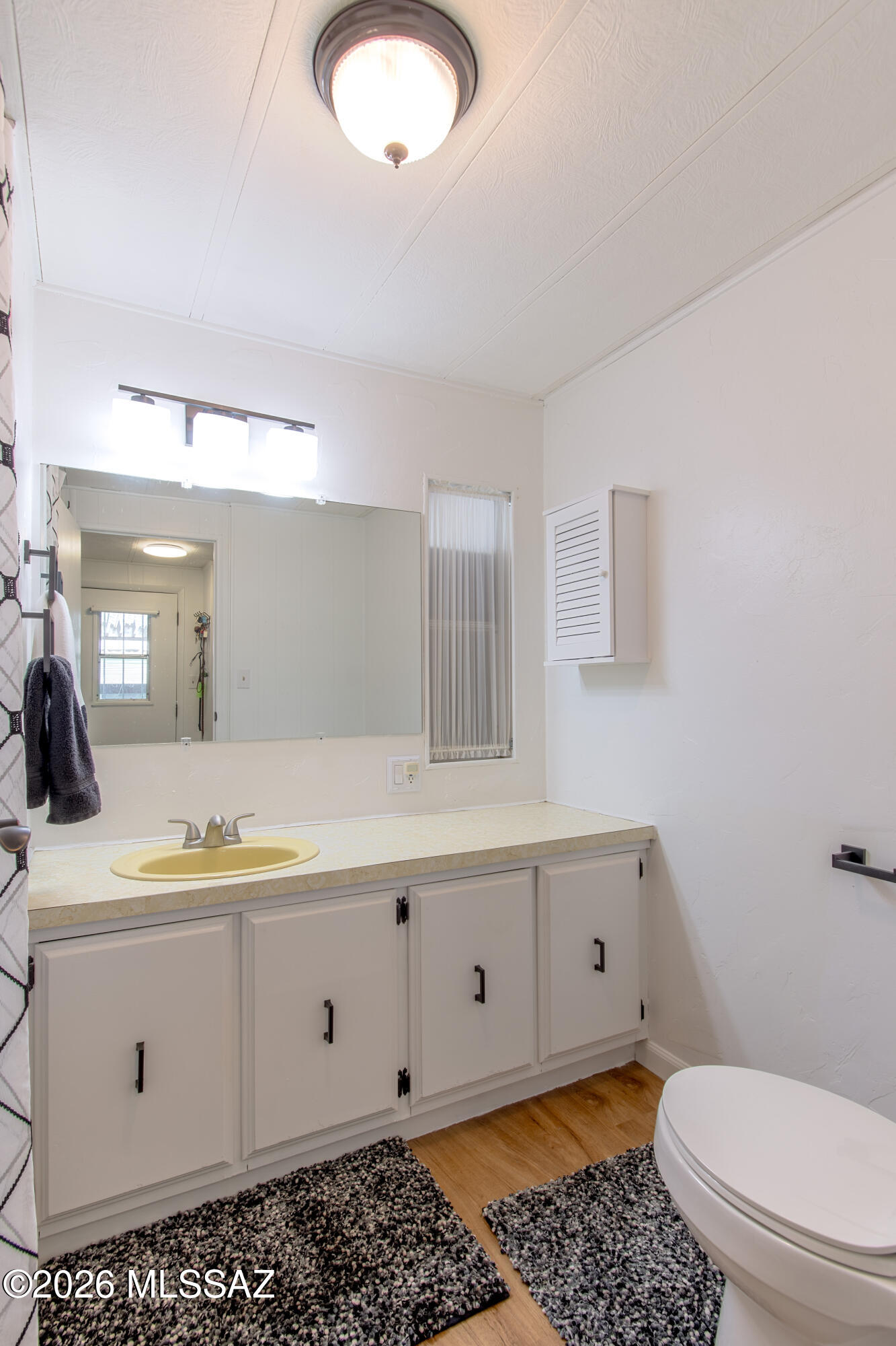 4550 North Flowing Wells Road, Unit 155 Tucson, AZ 85705 - Photo 22 of 40 a bathroom with a sink a toilet and mirror