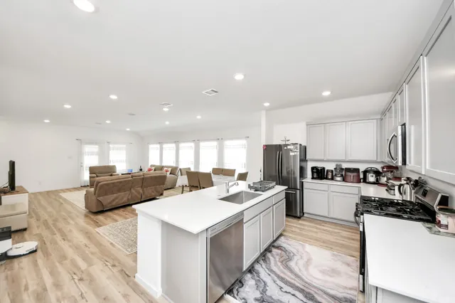 a kitchen with refrigerator a stove a oven a sink counter top space and furniture