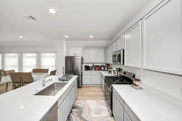 a kitchen with counter top space a sink a refrigerator and cabinets