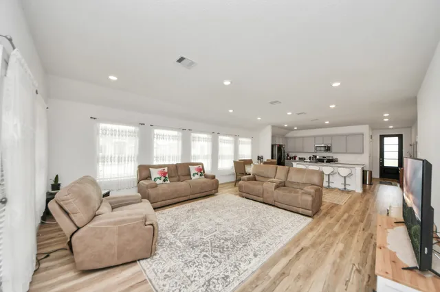 a living room with furniture and a wooden floor