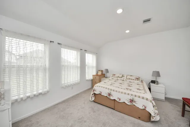 a bedroom with a bed and a large window