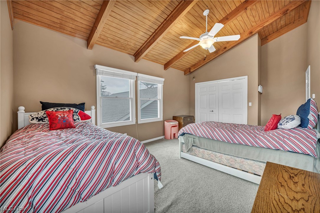 4741 Lake Road West Ashtabula, OH 44004 - Photo 30 of 43 Bedroom with lofted ceiling with beams, a closet, light colored carpet, wood ceiling, and ceiling fan