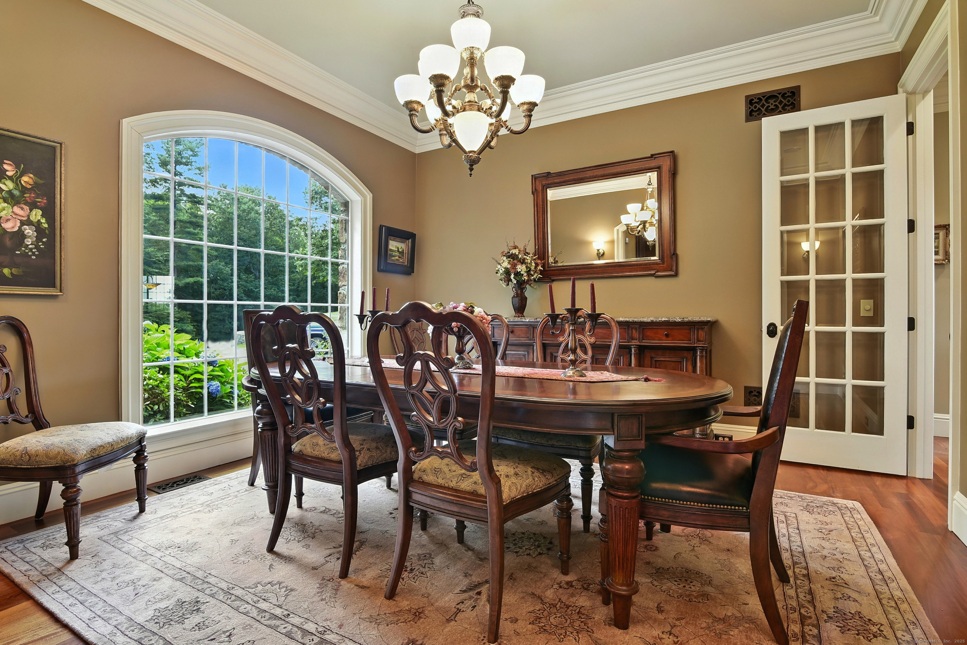 282 Searles Road Pomfret, CT 06259 - Photo 5 of 40 The mahogany floor, 10-foot ceiling, chandelier, sconces, single French door, and grand arched window lend the formal dining room an air of timeless sophistication.