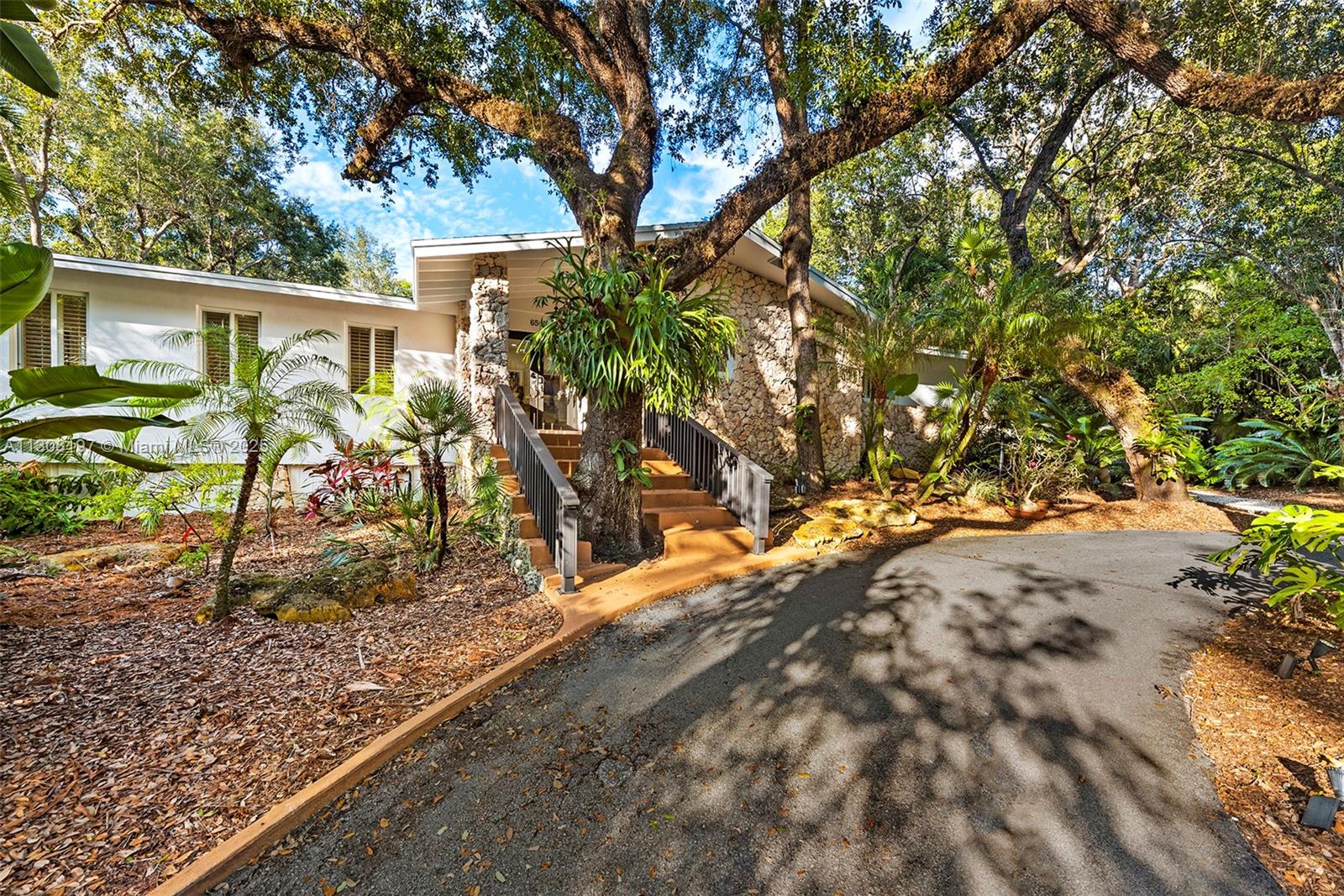 6565 Southwest 134th Drive Pinecrest, FL 33156 - Photo 1 of 1 a backyard of a house with table and chairs