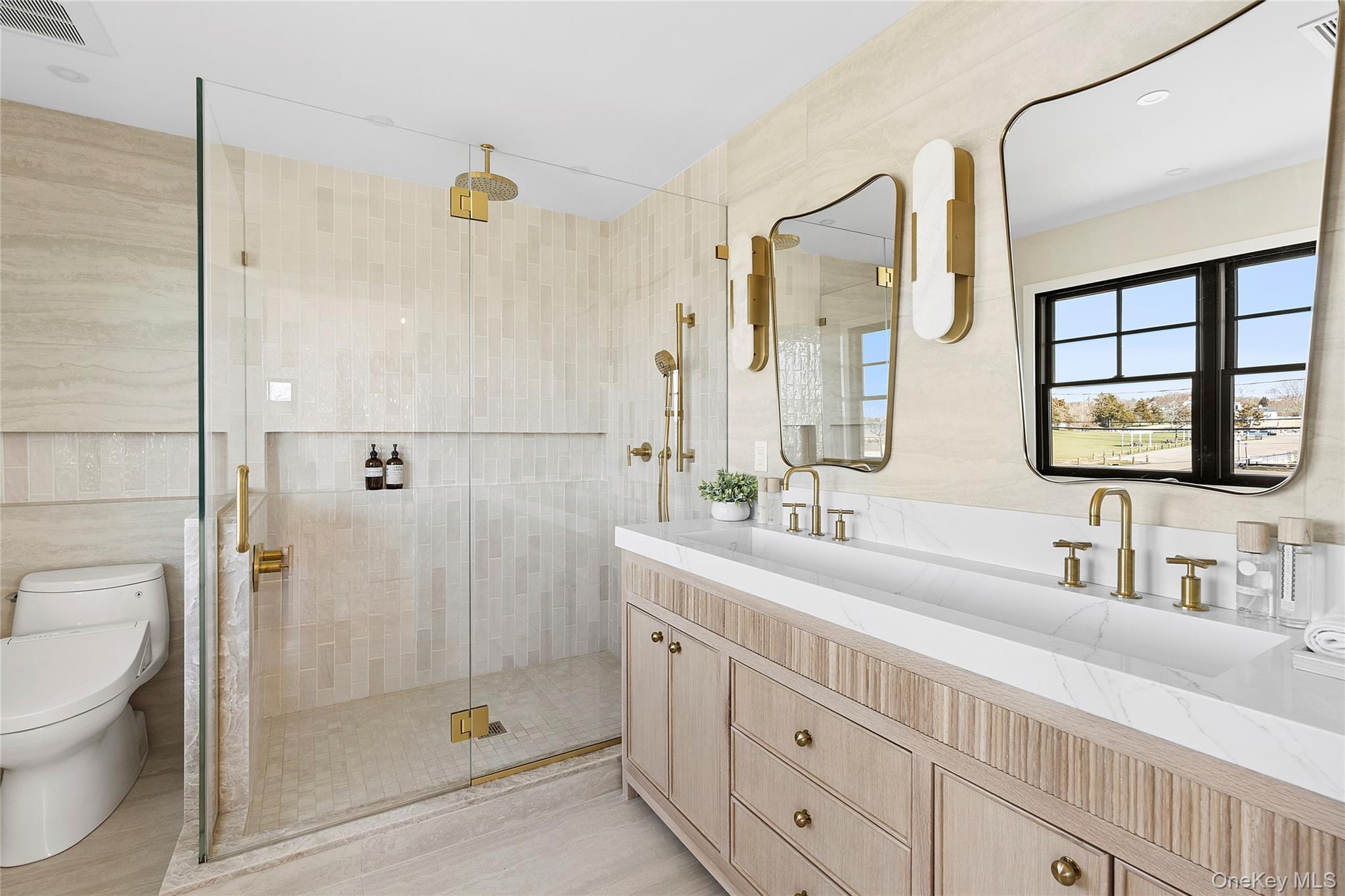 54 Library Avenue Westhampton Beach, NY 11978 - Photo 9 of 21 a bathroom with a double vanity sink toilet and shower
