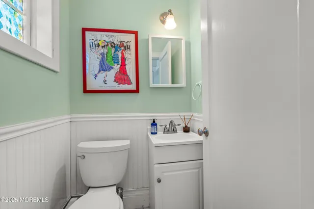 a bathroom with a toilet sink and mirror