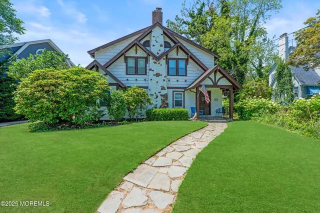 a view of a big house with a big yard potted plants and large tree