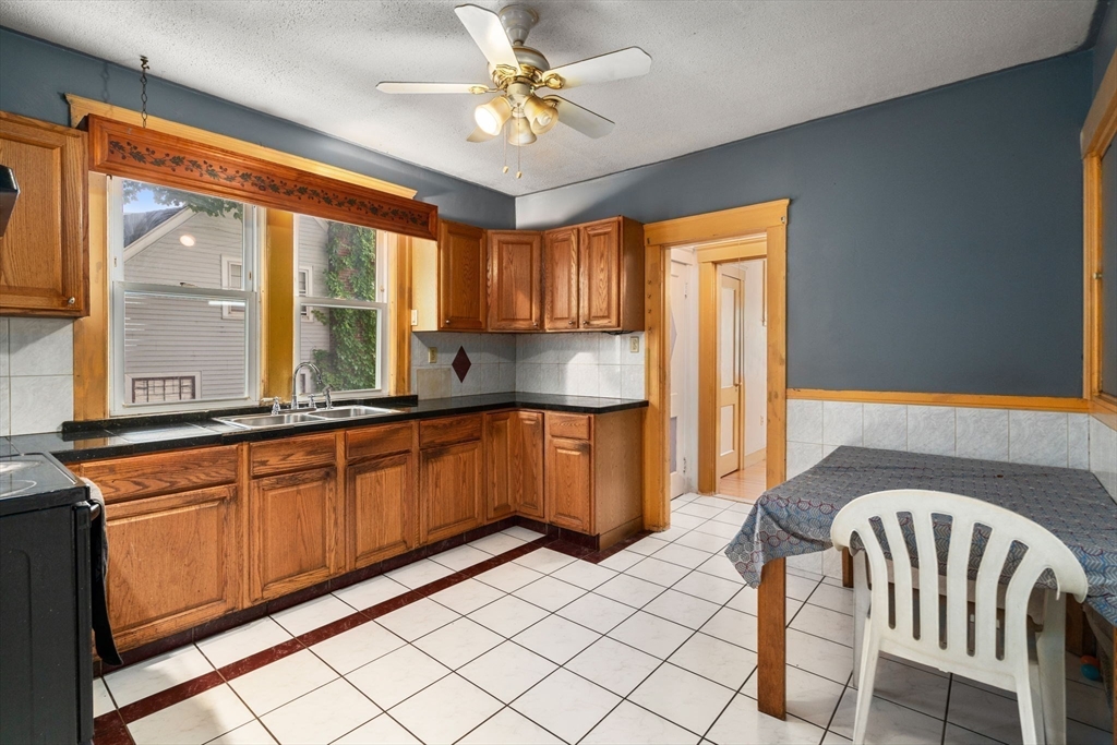 14 Channing Street Worcester, MA 01605 - Photo 7 of 16 a kitchen with granite countertop a sink and a refrigerator