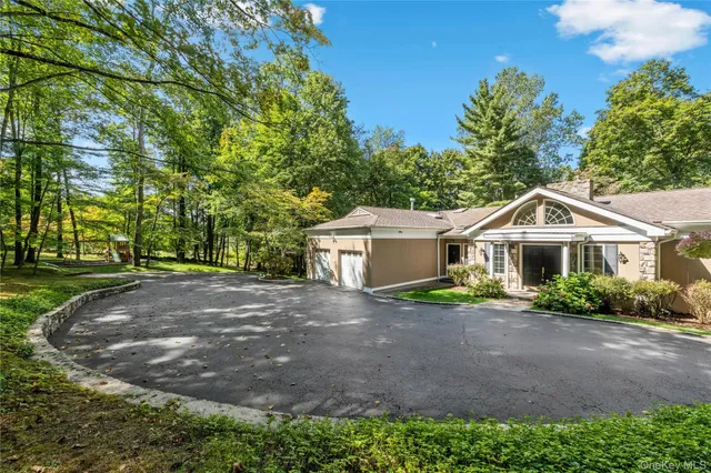 a view of a house with a yard and large trees