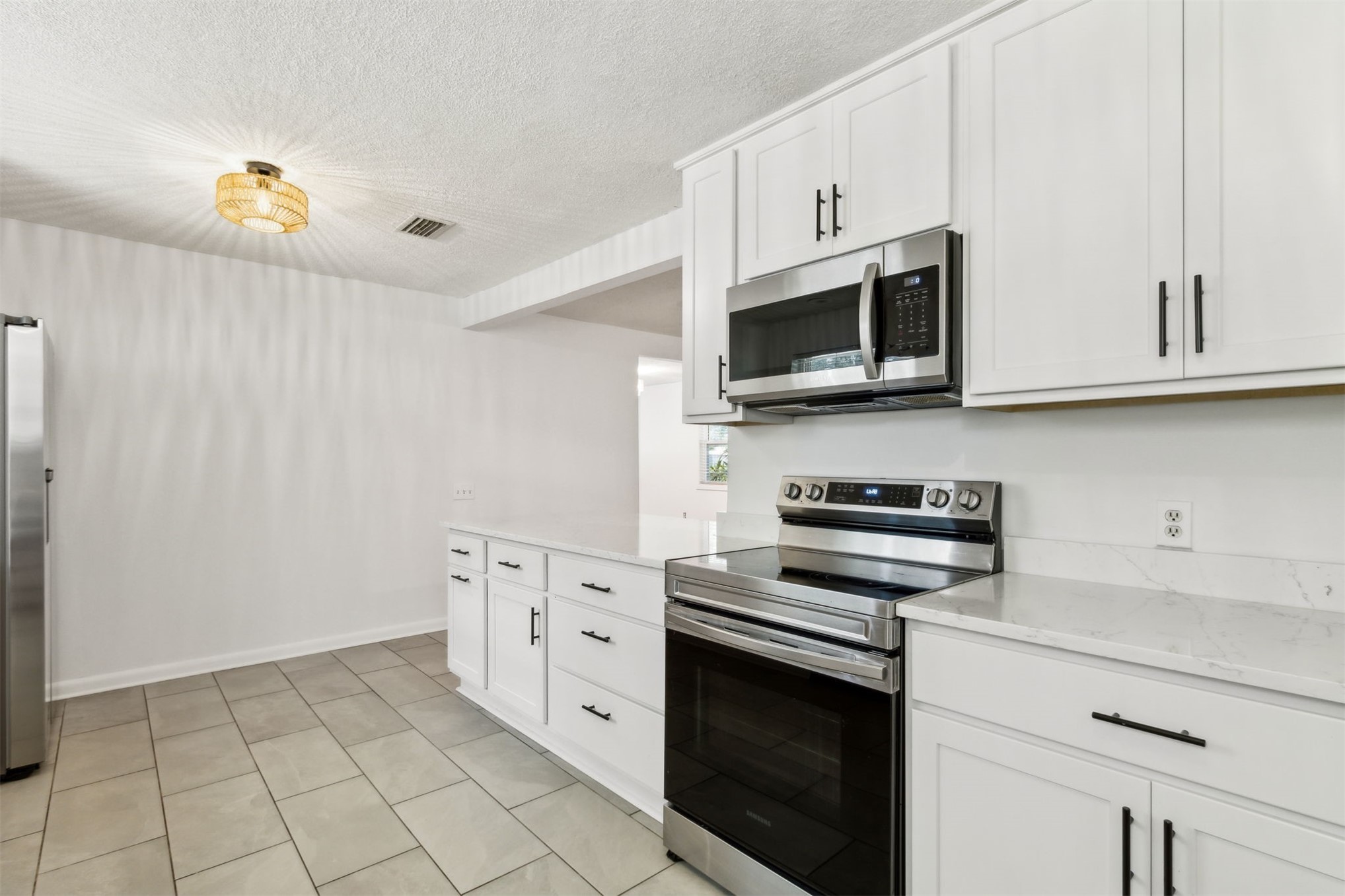 2441 Amelia Road Fernandina Beach, FL 32034 - Photo 16 of 36 a kitchen with granite countertop white cabinets stainless steel appliances and wooden floor