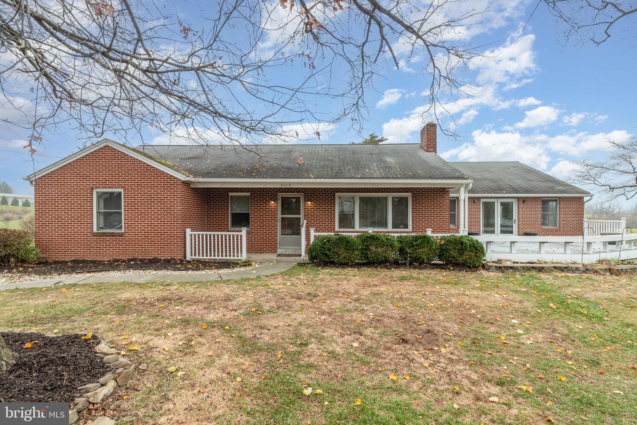a view of a yard in front of a house with large windows