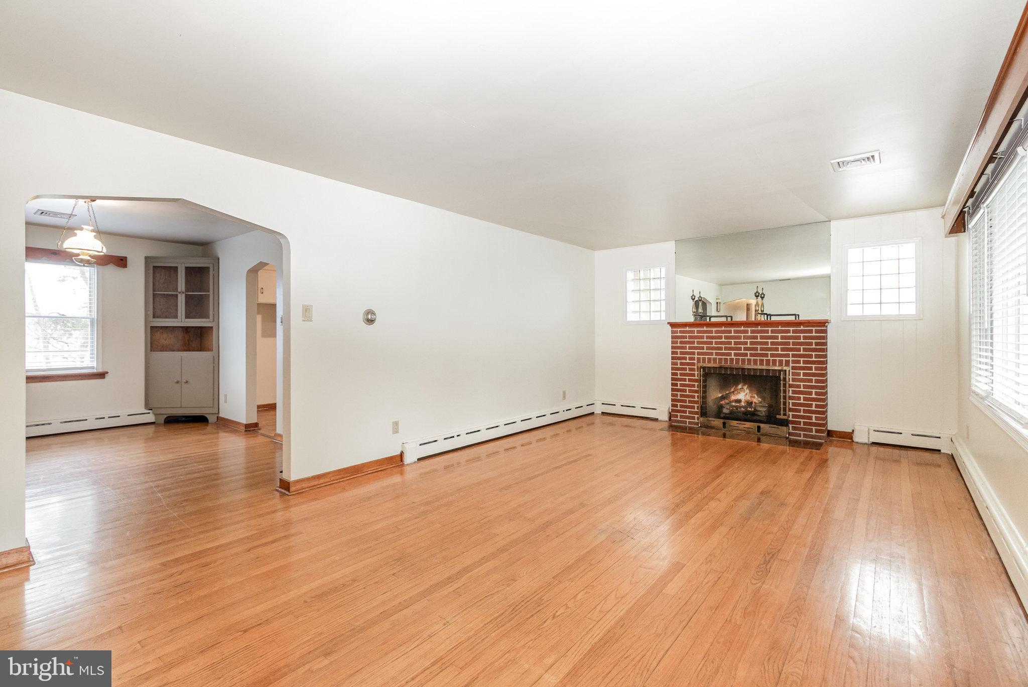 6112 Linglestown Road Harrisburg, PA 17112 - Photo 7 of 45 an empty room with wooden floor and fireplace