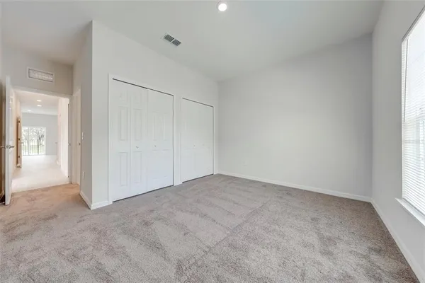 a view of a hallway with white cabinets