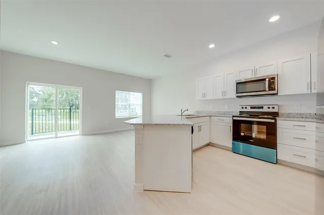 a kitchen with granite countertop a stove top oven and cabinets