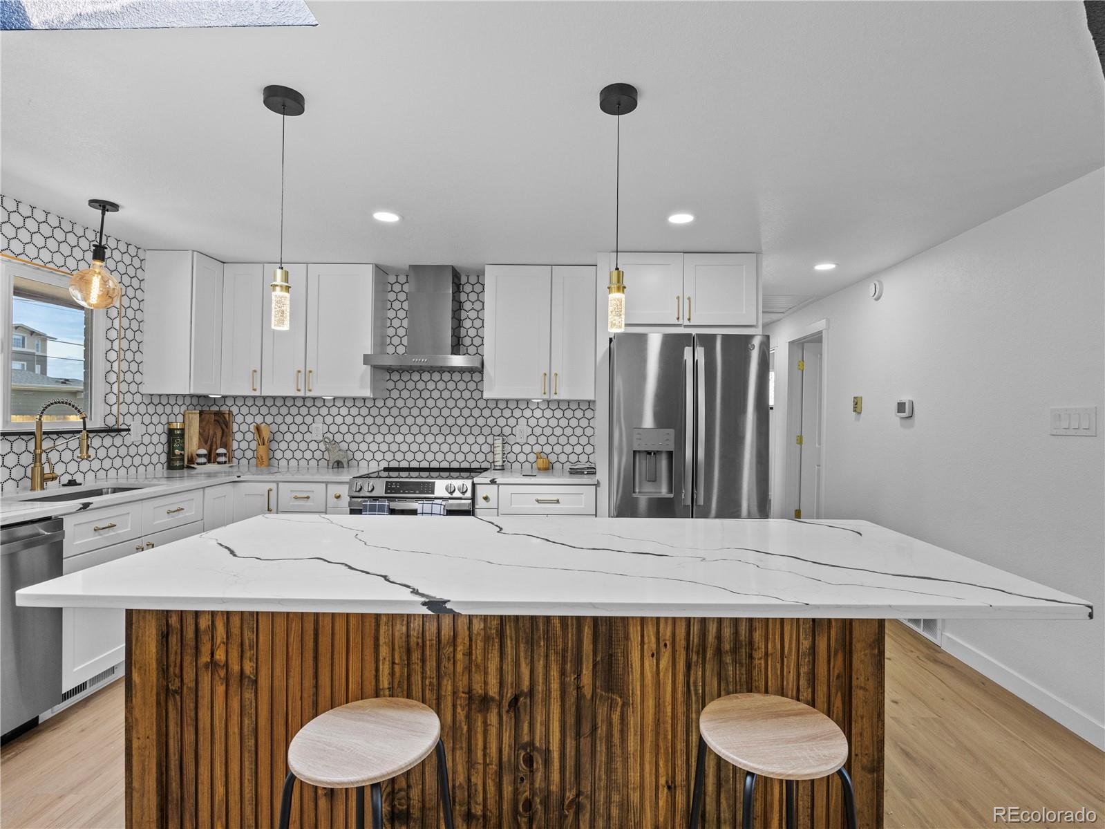 5673 Johnson Street Arvada, CO 80002 - Photo 14 of 40 a kitchen with a sink a refrigerator and trees